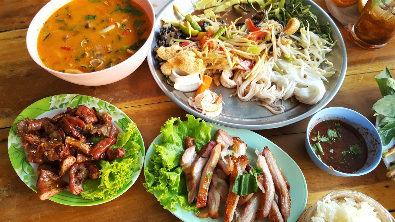 A table of grilled meats, salads and soup